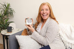 lady holding personalized silver dollar candle co candle smiling and laughing